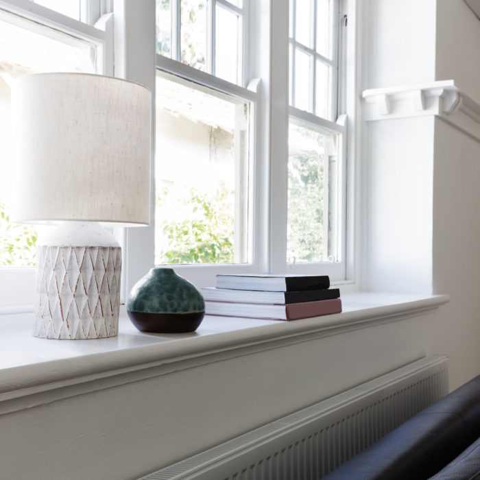 Close up details of lamp books and ornament objects on window sill